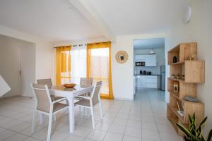 a kitchen and dining room with a table and chairs at Appartement les pieds dans l'eau in Sainte-Anne +15 photos