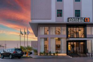 um edifício com um carro estacionado em frente em Marvelous Hotel em Tabuk