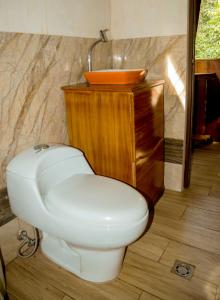 a bathroom with a white toilet and a sink at Caiman Eco Lodge in Aguarico