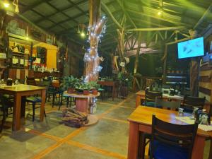 um restaurante com mesas e cadeiras e uma televisão em Guapote Lodge em Tigra