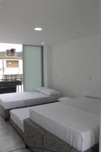 zwei Betten in einem Zimmer mit Fenster in der Unterkunft Villamagan in Carmen de Apicalá