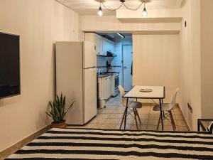 een keuken met een witte koelkast en een tafel bij Monoambiente moderno e inteligente en B Sur Cochera Precio en USD in San Miguel de Tucumán