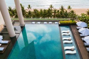 una vista aérea de una piscina con sillas y de la playa en Sheraton Nha Trang Hotel & Spa, en Nha Trang