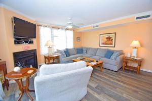 Bel Mare 101 condo في آوشين سيتي: غرفة معيشة بها أريكة وجهاز تلفزيون