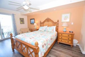 Bel Mare 101 condo في آوشين سيتي: غرفة نوم بسرير خشبي ومروحة سقف