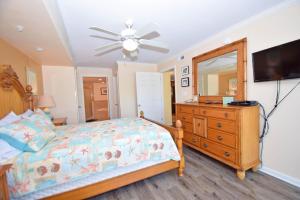 Bel Mare 101 condo في آوشين سيتي: غرفة نوم بسرير وخزانة ومرآة +9 صور