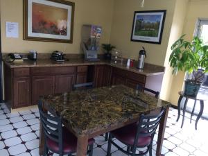 uma cozinha com uma mesa com cadeiras e um balcão em Knights Inn Augusta Fort Gordon em Augusta