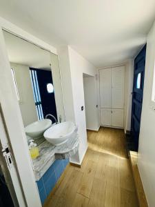 een badkamer met 2 wastafels en een spiegel bij HOLIDAY HOUSE EL OUALIDIA in Oualidia