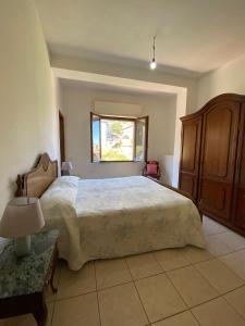 a bedroom with a large bed and a window at Casa Rosi in Villagrande Strisaili