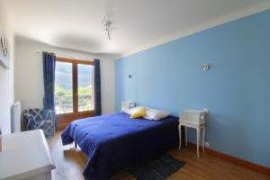 een blauwe slaapkamer met een bed en een raam bij Charming house with great views in Brison-Saint-Innocent +16 foto's