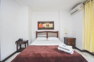 a bedroom with a bed with two towels on it at Hotel Estadio Real in Medellín