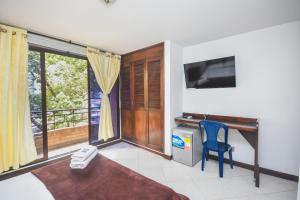 a living room with a blue chair and a television at Hotel Estadio Real in Medellín
