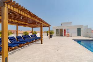 a group of chairs sitting on a patio next to a swimming pool at Casa Chance in Cartagena de Indias