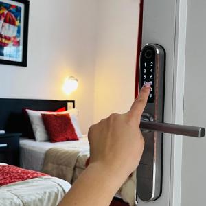 a persons hand is pressing a door handle in a hotel room at G6 Monoambiente King con Cochera en Villa Ángela in Villa Ángela