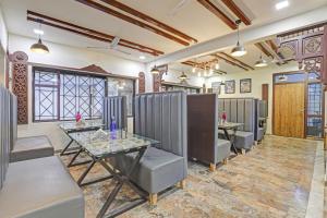 a restaurant with a table and chairs in a room at Collection O Hotel Dumas Rooms & Restaurant in Surat