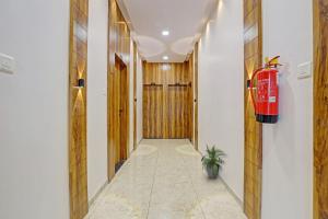 a hallway with a fire extinguisher on the wall at Collection O Hotel Dumas Rooms & Restaurant in Surat