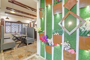a room with a green wall with flowers on it at Collection O Hotel Dumas Rooms & Restaurant in Surat