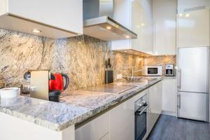 サン・マルタン・ド・レにあるLa Maisonnette Du Closのキッチン(白いキャビネット、大理石のカウンタートップ付)