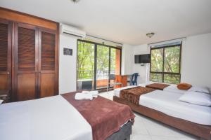 a hotel room with two beds and a tv at Hotel Estadio Real in Medellín +37 photos