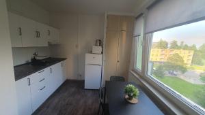 a kitchen with white cabinets and a large window at Apartmán Broumov in Broumov