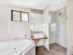 ein Badezimmer mit Badewanne, Waschbecken und Dusche in der Unterkunft Hibiscus Dreaming - Walking distance to the beach in Brooms Head + 13 Fotos