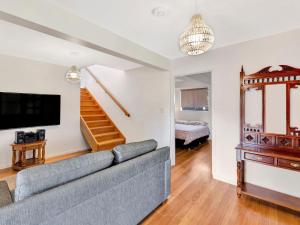 ein Wohnzimmer mit Couch und Fernseher in der Unterkunft Hibiscus Dreaming - Walking distance to the beach in Brooms Head