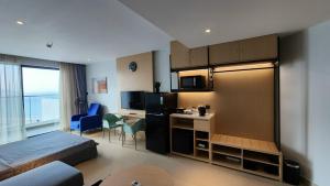 a hotel room with a bed and a desk and a kitchen at Happy Beach Seaview Condotel at The Arena Cam Ranh Resort in Cam Ranh
