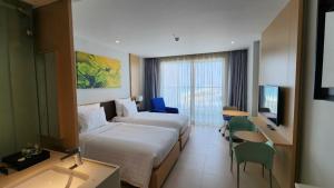 a hotel room with two beds and a television at Happy Beach Seaview Condotel at The Arena Cam Ranh Resort in Cam Ranh +72 photos