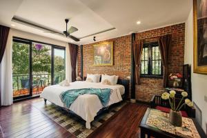 a bedroom with a bed and a brick wall at Art Museum Villa Hoi An in Hoi An +61 photos