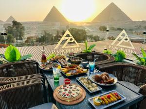 una tavola piena di alimenti con piramidi sullo sfondo di PANORAMA view pyramids a Il Cairo