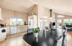 a kitchen and dining room with a black table and chairs at Nice Home In Tarm With Sauna in Tarm