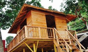 a tree house with a deck on top of it at Hanging Huts Resorts in Kotagiri