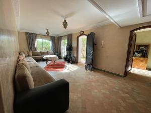 a living room with a couch and a tv at Villa plage tiguert résidence les méridiennes in Agadir