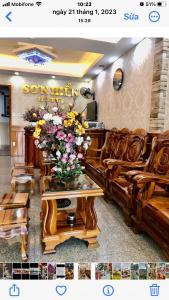 a room with a couch and a vase of flowers on a table at Khách Sạn Sơn Hiển in Cam Lâm