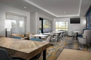 a dining room with tables and chairs and windows at TownePlace Suites Dallas DeSoto in DeSoto