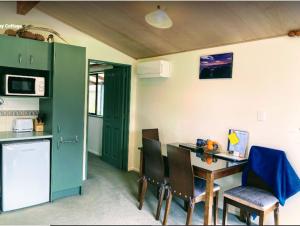 Height of Dunedin Serviced Farm Stay في دنيدن: مطبخ مع طاولة وكراسي في غرفة