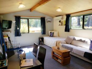 Height of Dunedin Serviced Farm Stay في دنيدن: غرفة معيشة مع سرير وأريكة