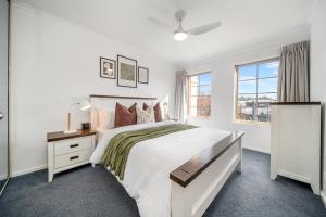 une chambre blanche avec un grand lit et une fenêtre dans l'établissement In The Midst on Melbourne, à Adélaïde