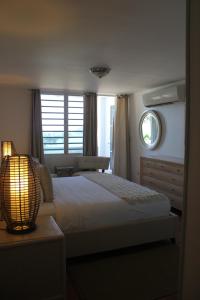 a bedroom with a bed with a lamp and a window at Hosteria del Mar in San Juan