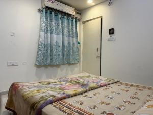 a bed in a room with a curtain and a window at 402 @ Vistaram in Vizianagram City