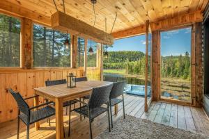 Sainte-Émélie-de-lʼÉnergieLes Boisés de la rivière noire的露台上摆着桌椅的餐厅