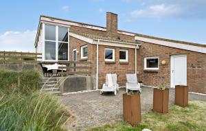 a brick house with two white chairs in front of it at Four-Bedroom Holiday Home In Hvide Sande in Bjerregård