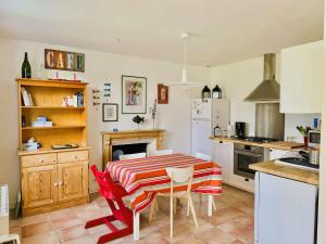 a kitchen with a table and chairs in a kitchen at Maison typique proche plage de Kerleven et golf, calme, jardin reposant, services de conciergerie - FR-1-481-165 in La Forêt-Fouesnant