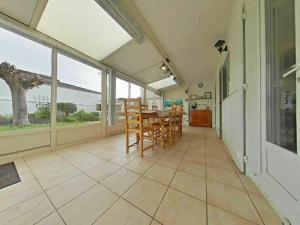 een eetkamer met een tafel, stoelen en ramen bij Maison 4 pièces près plage - Saint-Denis-d'Oléron, 6 couchages - FR-1-246A-309 in Saint-Denis-dʼOléron