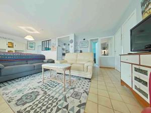een woonkamer met een bank en een tv bij Maison 4 pièces près plage - Saint-Denis-d'Oléron, 6 couchages - FR-1-246A-309 in Saint-Denis-dʼOléron