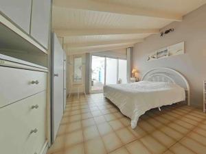 een grote slaapkamer met een bed en een groot raam bij Maison 4 pièces près plage - Saint-Denis-d'Oléron, 6 couchages - FR-1-246A-309 in Saint-Denis-dʼOléron