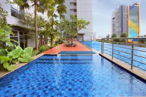 a large blue swimming pool in a building at Somerset Kencana Jakarta in Jakarta