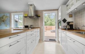 a kitchen with white cabinets and a door leading to a patio at 3 Bedroom Nice Home In Store Fuglede in Store Fuglede