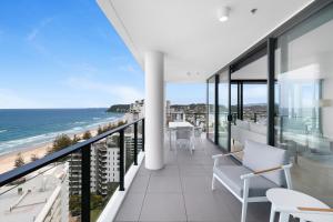 an apartment balcony with a view of the ocean at Sandbar Burleigh - Official in Gold Coast