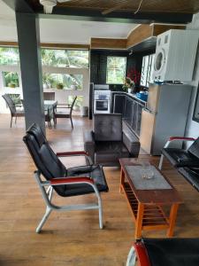 a kitchen and living room with chairs and a table at BIDESI VILLA Apartments in Suva